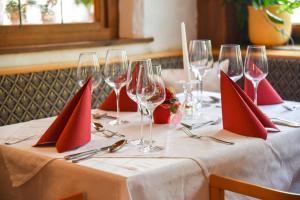 シャルニッツにあるGasthof Ramonaの赤いナプキンとワイングラスを添えたテーブル