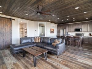 a living room with a leather couch and a table at Deer Ridge Casita: Private Retreat Hot Tub & Views in Orderville