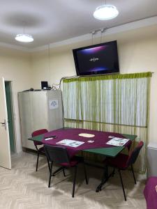 a room with a table with chairs and a tv on the wall at Cozy apartment in the center of Novi Sad! in Novi Sad