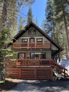 une grande maison avec une grande terrasse dans les bois dans l'établissement Quaint Cabin in Serene Lakes - Close to Skiing!, à Soda Springs