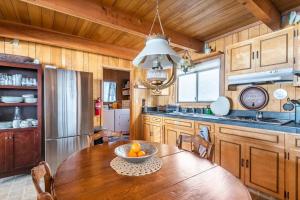 a kitchen with a wooden table with a bowl of fruit on it at Quaint Cabin in Serene Lakes - Close to Skiing! in Soda Springs