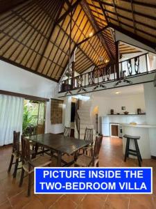 a dining room with a wooden table and chairs at Villa Lombok Senggigi Kamila Forest By Villaloka in Mangsit