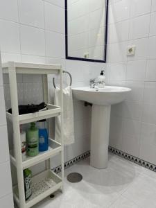 a white bathroom with a sink and a mirror at Apartamento Pinares del atlantico in Chiclana de la Frontera +17 photos