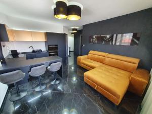 a living room with a couch and a kitchen at Black Brothers Wellness Apartments in Siófok