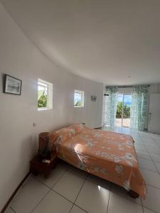 1 dormitorio con 1 cama en una habitación con ventanas en Te Tai Marama en Uturoa