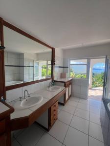 uma casa de banho com 2 lavatórios e um espelho grande em Te Tai Marama em Uturoa