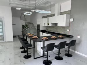 a kitchen with a black counter with black chairs at Sea View Chalet Al Ashkharah in Al Ashkharah