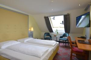 um quarto de hotel com uma cama, uma secretária e uma televisão em Celler Hof em Celle