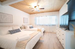 a bedroom with two beds and a flat screen tv at Stylish Heated Pool House Near The Beach in St Petersburg