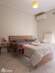 a bedroom with a large bed and a night stand at Spacious 2bedroom apartment in Chalkida