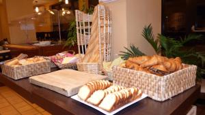 a table topped with baskets of bread and pastries at Central Hotel in Créteil