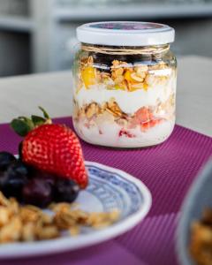 a jar of overnight oats with a plate of fruit at Hotel Roseliere Bucaramanga in Bucaramanga