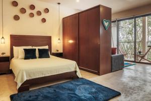 a bedroom with a large bed and a blue rug at 2 FREE BICYCLES BEAUTIFUL SUIT NEAR THE SEA BEAUTIFUL POOl in Tulum +47 photos