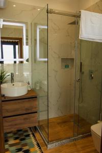 a bathroom with a glass shower and a sink at Villa Teverde in Shkodër