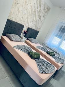 two beds with pillows on them in a bedroom at Kabashi Apartment in Krk
