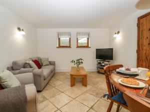 a living room with a couch and a table at Bluebell Cottage in Leominster