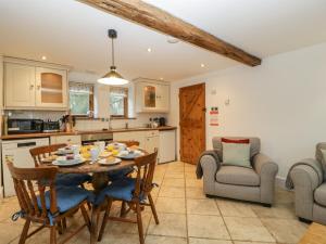 a kitchen and dining room with a table and chairs at Bluebell Cottage in Leominster