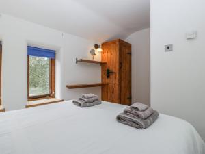 a bedroom with a white bed with towels on it at Bluebell Cottage in Leominster