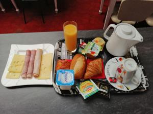 - un plateau de nourriture avec du pain à la saucisse, du fromage et du jus d'orange dans l'établissement hôtel le Celtic Montluçon, à Montluçon