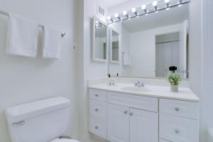 uma casa de banho branca com um lavatório e um espelho em Spacious 2 Bedrooms Apt @Crystal City With Gym em Arlington