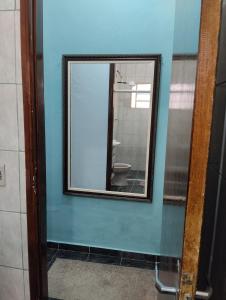 einen Spiegel an einer blauen Wand im Bad in der Unterkunft Casa do vovô in Aparecida