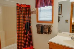 a bathroom with a plaid shower curtain and a sink at Big Foot Bungalow in Sevierville +26 photos
