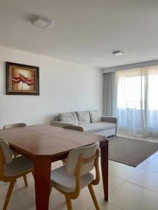 a living room with a table and a couch at Dpto de 1 dormitorio, 402 Dos Orillas, Colonia in Colonia del Sacramento