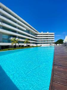 a swimming pool in front of a building at Monoambiente 509, Dos Orillas in Colonia del Sacramento