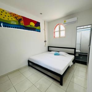 - une chambre avec un lit et une peinture murale dans l'établissement Hospedaje Casa Cultural Saberes, à Neiva