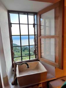 a sink in a bathroom with a window at Magical cottage! in Agios Georgios Nilias