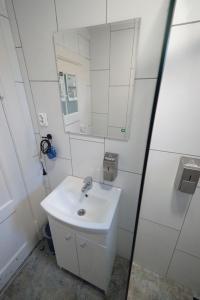 uma casa de banho branca com um lavatório e um espelho em Mostek 32 Silent Apartment em Gdansk