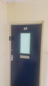 a blue door with a window in a room at Budget Rooms in Fort William