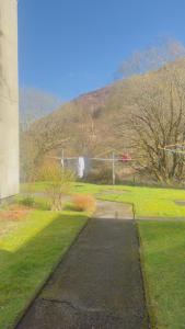 a walkway in a park with a hill in the background at Budget Rooms in Fort William