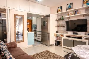 uma sala de estar com um sofá e uma televisão em AP NA BELA VISTA, PRÓXIMO AO BEXIGA, STUDIO PRIVATIVO E COMPLETO em São Paulo