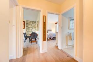 Un pasillo con una habitación con una cama y una mesa en Bright Charming Apartment In Ealing, en Londres