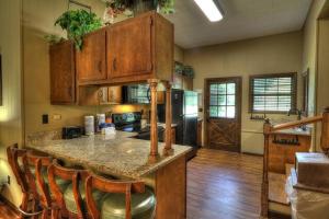 a kitchen with a island with chairs and a counter top at Cap's Fishin' Camp #542 in Sevierville