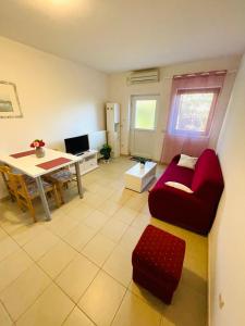 ein Wohnzimmer mit einem roten Sofa und einem Tisch in der Unterkunft Lavanda 3 in Njivice