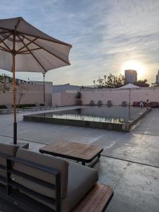patio ze stołem, parasolem i basenem w obiekcie Departamento Brittania Tower w mieście Guadalajara