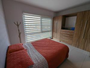 sypialnia z łóżkiem i oknem z telewizorem w obiekcie Departamento Brittania Tower w mieście Guadalajara