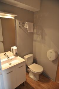 een badkamer met een wit toilet en een wastafel bij Relais de Barbezieux in Barbezieux