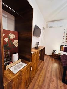 um quarto com um armário de madeira e uma televisão. em Hotel Fjorr em Prizren