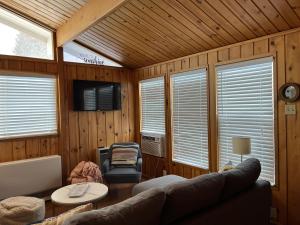uma sala de estar com um sofá e uma televisão e paredes de madeira em Bryce’s Zion House by Bryce Canyon National Park! em Panguitch
