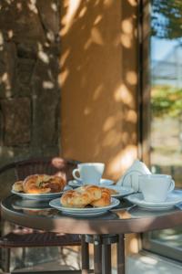 dos platos de repostería y tazas en una mesa en Posada Bonarda en San Rafael