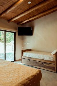 a bedroom with two beds and a flat screen tv at Posada Bonarda in San Rafael