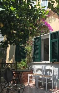 ラ・スペツィアにあるLittle Lemon Gardenの緑窓のある建物の前にテーブルと椅子