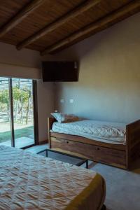 a bedroom with two beds and a tv on the wall at Posada Bonarda in San Rafael