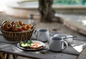 a table with a basket of fruit and a plate of bread at Casa Magu Merida in Mérida +33 photos