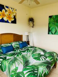 1 dormitorio con 1 cama con edredón verde y blanco en Heiata Lodge Papeete en Papeete