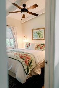 een slaapkamer met een bed en een plafondventilator bij Māla o Kilauea Nature Retreat in Pahoa