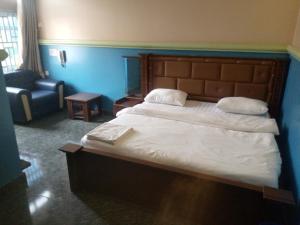 ein Schlafzimmer mit einem großen Bett und einem Stuhl in der Unterkunft De Jacob's Hotel & Suites in Umuinya